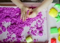 Kid`s hands with kinesthetic sand