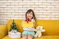 The girl is presenting a Christmas gift. girl showing the gift box. Cute asian kid holding a Christmas box. happy new year. Merry