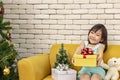The girl is presenting a Christmas gift. girl showing the gift box. Cute asian kid holding a Christmas box. happy new year. Merry