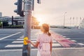 girl presses the button on the traffic light to turn green and cross the road safely