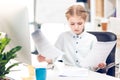 Girl pretending to be businesswoman and working with documents and computer in office Royalty Free Stock Photo