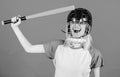 Girl pretty blonde wear baseball helmet and hold bat on blue background. Beat her head with bat. Dumb idea concept. Girl