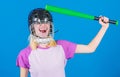 Girl pretty blonde wear baseball helmet and hold bat on blue background. Beat her head with bat. Dumb idea concept. Girl