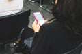 A girl prints a message on her smartphone in a pink case