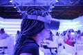 Girl in profile with braids wearing VR virtual reality glasses with neon lights background vertically