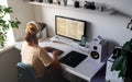 Girl programmer in the modern developer workplace for writing code with white computer desktop and comfy armchair.