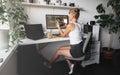 Girl programmer in the modern developer workplace for writing code with white computer desktop and comfy armchair.