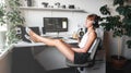 Girl programmer in the modern developer workplace for writing code with white computer desktop and comfy armchair.