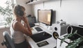 Girl programmer in the modern developer workplace for writing code with white computer desktop and comfy armchair.