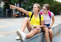 Girl prompts the girlfiend, pointing with his hand at something