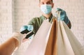 Girl in protective gloves checking out with credit card for shopping delivery