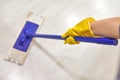 Girl in protective gloves cleaning floor using flat wet mop Royalty Free Stock Photo