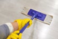 Girl in protective gloves cleaning floor using flat wet mop Royalty Free Stock Photo