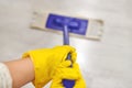 Girl in protective gloves cleaning floor using flat wet mop Royalty Free Stock Photo