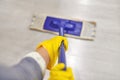 Girl in protective gloves cleaning floor using flat wet mop Royalty Free Stock Photo