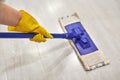 Girl in protective gloves cleaning floor using flat wet mop Royalty Free Stock Photo