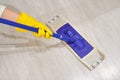 Girl in protective gloves cleaning floor using flat wet mop Royalty Free Stock Photo