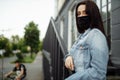 Girl in a protective mask on a balcony looks at an empty city Royalty Free Stock Photo