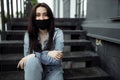 Girl in a protective mask on a balcony looks at an empty city Royalty Free Stock Photo