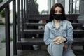 Girl in a protective mask on a balcony looks at an empty city Royalty Free Stock Photo