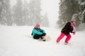 Girl pulling mother on toboggan Royalty Free Stock Photo
