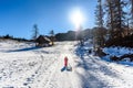 Girl is pulling snow sledge in ski resort wearing winter clothe