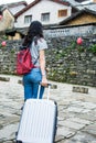 Girl pulling the suitcase walking in the ancient town Royalty Free Stock Photo