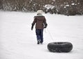 Girl pulling tube up sledding hill Royalty Free Stock Photo