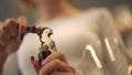Girl pulls the cork from a wine bottle with a corkscrew close-up. A girl with a beautiful manicure uncorking bottle of