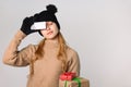 Girl purchases New Year`s gifts and hides an eyes with discount card. Spaces Royalty Free Stock Photo