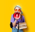 Girl in purple clothes with pink megaphone and books