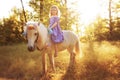 Girl in purple dress hugging white unicorn horse. Dreams come true. Fairy tale Royalty Free Stock Photo