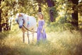 Girl in purple dress hugging white unicorn horse. Dreams come true. Fairy tale Royalty Free Stock Photo