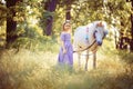 Girl in purple dress hugging white unicorn horse. Dreams come tr Royalty Free Stock Photo