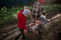 A girl pushes a bicycle with her older brother. Children of immigrants