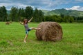 The girl pushes a haystack.