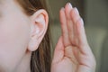 the girl put her hand to her ear. the girl is listening. the girl's ear hurts. the girl has an ear disease. to gossip Royalty Free Stock Photo