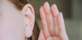 the girl put her hand to her ear. the girl is listening. the girl's ear hurts. the girl has an ear disease. to gossip Royalty Free Stock Photo