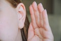 the girl put her hand to her ear. the girl is listening. the girl's ear hurts. the girl has an ear disease. to gossip Royalty Free Stock Photo