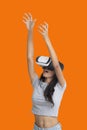 Girl put her hands up while playing multimedia game with virtual reality glasses Royalty Free Stock Photo