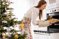 The girl puts a baking tray with Christmas cookies in the oven Royalty Free Stock Photo