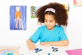 Girl puts blue coins learning to count Royalty Free Stock Photo