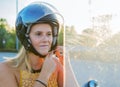 Girl puts on a helmet to go on a scooter