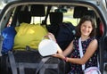 Girl puts her purse on the car before leaving on vacation Royalty Free Stock Photo