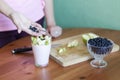 The girl puts the pieces of green apples in a glass of yogurt Royalty Free Stock Photo