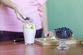 The girl puts the pieces of green apples in a glass of yogurt Royalty Free Stock Photo