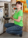 Girl putting griddle into refrigerator Royalty Free Stock Photo