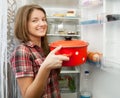 Girl putting pan into fridge Royalty Free Stock Photo