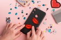 Girl putting red lips patches on black phone case