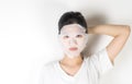 Girl in putting on a skin care paper mask